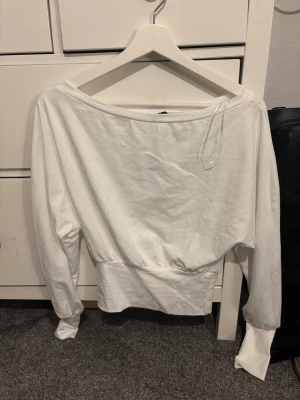 Vit långärmad topp från Gina Tricot - Säljer en vit långärmad topp från Gina Tricot i storlek XS. Modellen har breda muddar vid ärmslut och midja, samt en lösare passform upptill. Toppen är tillverkad i mjuk bomull och har en enkel, stilren design med rundad hals.