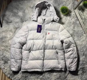 Vit pufferjacka från Polo Ralph Lauren - Säljer en vit pufferjacka från Polo Ralph Lauren med huva och dragkedja framtill. Jackan har två sidofickor med dragkedja och det klassiska röda Polo-logot på bröstet. Materialet är polyester och jackan är quiltad för extra värme.