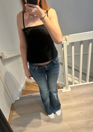 Svart topp - Säljer en enkel och stilren armlös topp från Bikbok i storlek S. Perfekt för att skapa en mängd olika outfits, från avslappnade till mer uppkläda! Plagget har gummiband då den sitter på plats! Har kommit till användning fåtal gånger. Djur och rökfritt hem! Pris kan diskuteras! 🚛👀✨