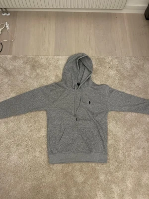 Ralph Lauren Hoodie - Mycket fin mörk grå hoodie. Hade behållt den men tyvärr lite för liten. Men annars 10/10. Helt oanvänd. Vid snabb affär kan pris diskuteras.