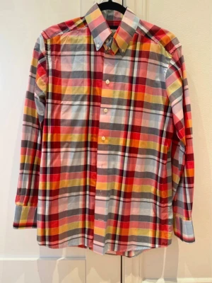 Eton skjorta i färgstarkt rutmönster - Snygg och elegant Eton-skjorta i klassiskt rutmönster med livfulla färger. Tillverkad i Etons exklusiva bomull med perfekt passform i slim fit-modell. En skjorta som passar lika bra till jeans som under kavajen – perfekt för dig som vill addera lite färg och stil till vardagen eller jobbet.  ✅ Storlek: 38 Contemporary ✅ Kvalitet: 100% bomull ✅ Skick: Mycket gott skick ✅ Från djur- och rökfritt hem