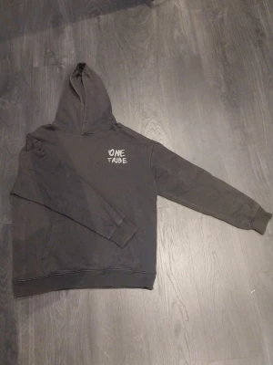 Grå hoodie - Säljer nu denna One Tribe hoodien då den inte används längre. Den är i storlek 170 men sitter som S. Den är i väldigt bra skick då den knappt använts.