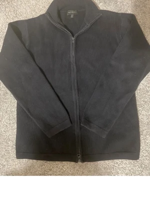 Svart stickad kofta från Steel - Klassisk svart stickad kofta från Steel i storlek S. Tröjan har hel dragkedja framtill, hög krage och långa ärmar. Perfekt för lager på lager och enkel att matcha med olika outfits.