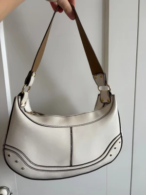 Vit axelväska i skinn med detaljer - Cool vit handväska i skinn. Tyvärr vet jag inte var den är ifrån då den är köpt secondhand🥰