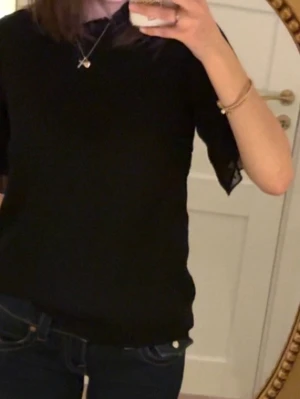 Svart blus med prickigt mönster - Snygg svart blus med korta ärmar och diskret prickigt mönster.