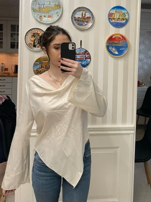 Blus - Asymetrical blus som är krämvit. Använts en gång!