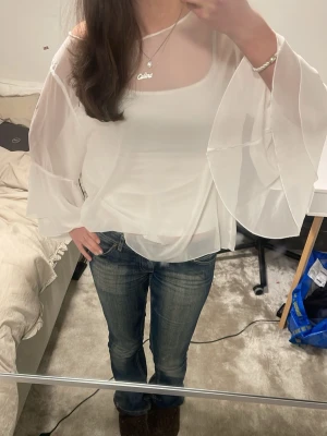 Vit blus med vida ärmar - Säljer en snygg vit blus, den är genomskinlig jag vet inte märket då det inte finns tagg så vet ej storleken. Pris går att diskuteras vid snabbt köp