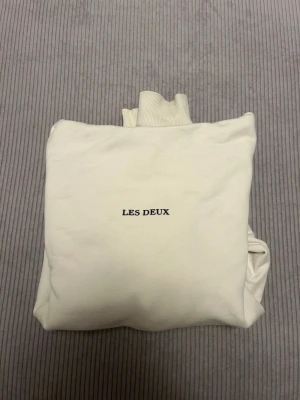 Vit hoodie från Les Deux strl M - Vit hoodie från Les Deux i storlek M. Tröjan är i mycket gott skick och säljs på grund av att den är för liten. Tröjan är helt nytvättat och redo för leverans. Hör av dig vid frågor😊