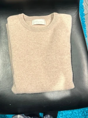 Beige stickad tröja från sayless - En stilren beige stickad tröja från sayless med rund halsringning och klassisk passform. Perfekt för lager-på-lager och enkel att matcha med olika outfits. Mjuk och skön känsla.