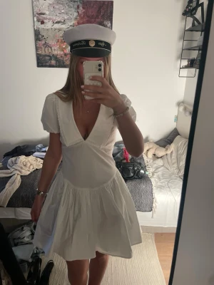 INTRESSEKOLL Vit kort studentklänning med puffärm - INTRESSEKOLL. Säljer för lägst 800kr, om flera är intresserade kommer jag göra budgivning tills fredag. Därmed kommer jag inte skicka iväg den direkt om någon köper den för 800kr och någon annan hinner buda högre. Söt vit kortklänning med puffärmar och djup v-ringning. Klänningen har en volangig kjol och markerad midja, perfekt för student eller sommar. Den är bara använd vid studenten 