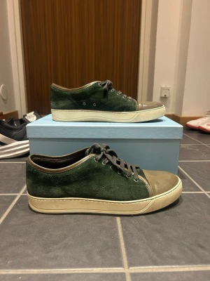 Mörkgröna mocka sneakers med snörning - Äkta Lanvin skor, box ingår. Färg grön, tecken på användning men i bra skick, inga hål. Storlek 44. Fraktar oftast direkt eller dagen efter📦.