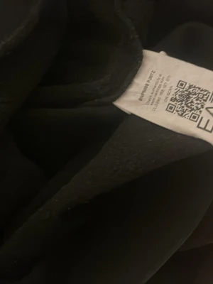 Svart hoodie från EA7 Emporio Armani - Säljer en svart hoodie från EA7 Emporio Armani. Hoodien har en klassisk design med huva och är tillverkad i mjukt material som känns skönt mot huden. Perfekt för en avslappnad och stilren look.