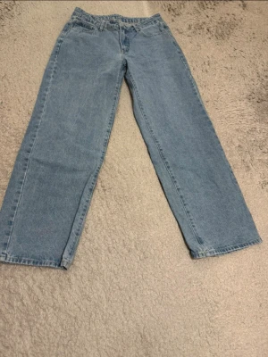 Ljusblå raka jeans i klassisk modell - Säljer ett par ljusblå jeans med rak passform och klassisk femficksdesign. Jeansen har normal midja och är tillverkade i slitstarkt denimtyg av bomull. Perfekta för en avslappnad och tidlös stil.