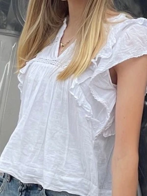 Vit volangblus med spetsdetaljer - Jätte söt vit blus från Neo Noir som tyvärr blivit för liten. Lite osäker på storlek men skulle gissa XS/32