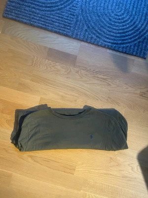 Ralph Lauren långärmad tröja  - Säljer nu en mörkgrön långärmad tröja från Polo Ralph Lauren i storlek XL barn/ S i vanlig storlek. Passar nog runt 170-180 beroende på hur man vill den ska sitta. Perfekt basplagg i mjuk bomull/ t shirt material som funkar till det mesta. Skicket är bra, inga hål eller fläckar. Mått längd: cirka 64 cm. 