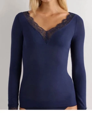 Mörkblå intimissimi tröja med spets - Snygg mörkblå långärmad topp med v-ringning och spetsdetaljer vid halsringningen och ärmsluten. Figurnära passform och mjukt material som känns skönt mot huden. Perfekt att styla med jeans eller kjol för en trendig look.