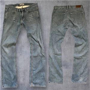 Acne jeans 30/32 - Säljer ett par ljusblå Acne Max Contrast Light jeans i klassisk femficksmodell. Jeansen har raka ben, normal passform och är tillverkade i 100% bomull. Snygga slitningar framtill och kontrastsömmar ger en cool vibe. Perfekt för dig som gillar stilrena jeans.