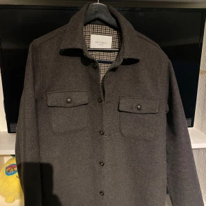 Brun jacka från Les Deux - Säljer en snygg brun jacka från Les Deux. Jackan har en klassisk krage och är långärmad. Perfekt för en stilren look.