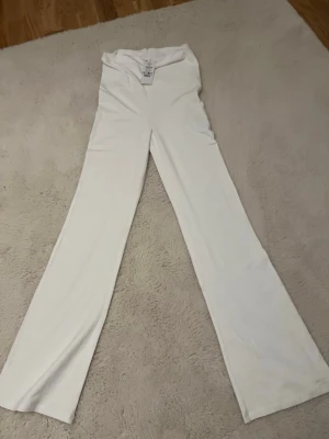 Vita low waist yoga leggings - Säljer ett par vita yoga leggings med låg midja i storlek 146/152. De har en clean och enkel design med raka ben och är perfekta för dig som gillar att röra på dig. Materialet är mjukt och stretchigt för maximal komfort. Har inte  används. 