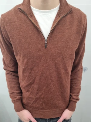 Brun merinoulltröja med half zip - Snygg brun långärmad tröja från Invento Italy i 100% merinoull. Tröjan har en klassisk krage och half zip-dragkedja framtill, vilket ger en chill och stilren look. Perfekt för lager-på-lager och passar till jeans eller chinos. 170-175cm