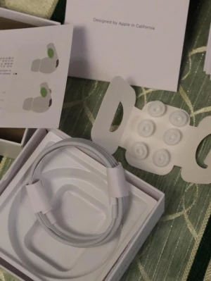 AirPods Pro2 - Apple AirPods Pro2 med laddningsetui, extra öronkuddar och laddningskabel. Produkten ser ut att vara i mycket gott skick, komplett med originalförpackning och manualer. Aktiv brusreducering och trådlös anslutning för bästa ljudupplevelse. Perfekt för musik, samtal och träning.