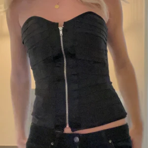 Korsett topp - Svart cool korsett topp i storlek S ifrån Charlotte russe 💗 Smått skadad under ena armen då ett armband nöttit mot tyget se bild 3