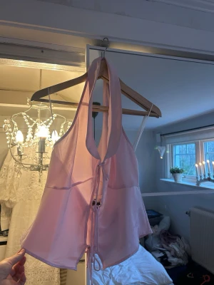 Ljusrosa halterneck linnetopp - Säljer en ljusrosa halterneck linnetopp med snörning framtill. 