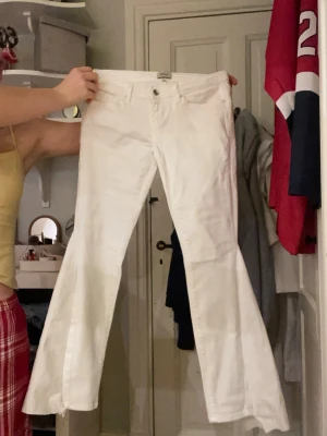Lågmidjade vita jeans - Säljer dessa lågmidjade jeans som är utsydda till bootcut. Jeansen är i stretchigt matrial och fint skick, inga fläckar eller liknande. Midjrmått 36 cm och innerbenslängd 70 cm. Kontakta mig privat vid frågor eller liknande 💗💗