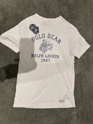 Polo Bear T-Shirt - Säljer en asfet T-shirt från Polo Ralph Lauren från deras ”Polo Bear” kollektion. Den har tryck och patches på framsidan och tryck på baksidan. Grymt skick utan defekter vad jag kan se. Självklart äkta. Storlek L/14-16 barn, passar XS