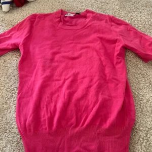 Rosa stickad tröja från Zara - En snygg rosa stickad tröja från Zara med rund halsringning och kortare ärmar. Tröjan har en mjuk och stretchig känsla. Använd fåtal gånger, tar frakt
