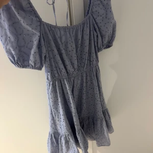 Ljusblå kortklänning & Other Stories - Supersöt ljusblå kortklänning från & Other Stories med broderade detaljer och puffärmar. Klänningen har resår i midjan, volang nertill och knytning i ryggen. I väldigt bra skick då den endast är använd 2 ggr. Ny pris är 895kr. Kan sänka vid snabb affär. 