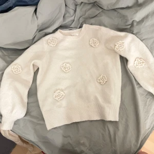 Vit stickad tröja med blommor - Superfin vit stickad tröja från Dobber i storlek M, dock har den råkat krympt i tvätten så den sitter som en xs/s. Tröjan har söta stickade blommor framtill🌸💕