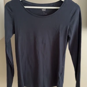 Mörkblå långärmad tröja - En basic mörkblå långärmad tröja från 157 med rund halsringning. Tillverkad i mjuk bomull. Enkel och stilren design som funkar till allt.