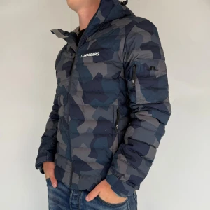 J.Lindeberg Jacka - Vi säljer nu denna stilrena camo jackan i märket J.Lindeberg! Jackan är i storleken S men passar S/M, modellen på bilden är 180cm 75kg. Jackan är i gott skick med små defekter. Det är en skidjacka men fungerar även perfekt för vardagsbruk! Skriv för frågor och funderingar!