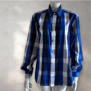 Jack e Jones blårutig skjorta  - Snygg skjorta med stora blå, vita och grå rutor från Jack e Jones Skjortan har klassisk krage, långa ärmar och knäppning framtill. Perfekt för dig som gillar en stilren men ändå färgstark look.#jackejones