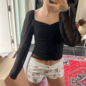 HELT NY Svart blus från Bubbleroom  - Supersnygg svart blus från Bubbleroom. Toppen har en snörning i mitten som kontrollerar längden på toppen. Ärmarna är transparenta och ger en cool look. Perfekt för fest, vardag eller hemmaoutfit, älskar den❤️🌸