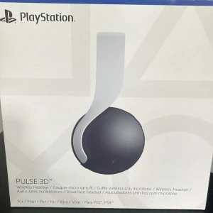 PlayStation Pulse 3D Wireless Headset - PlayStation Pulse 3D trådlöst headset, kompatibelt med PS5 och PS4. Snygg design i svart och vitt, med inbyggd mikrofon och lättåtkomliga kontroller. Hörlurarna ser ut att vara i gott skick utan synligt slitage. Perfekt för spel med 3D-ljud och chat.