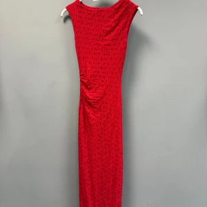 Röd långklänning med slits - Snygg röd långklänning i strukturerat tyg med draperad detalj på sidan och slits framtill. Materialet har en lätt glans och känns lyxigt💗💗passar xs/s!