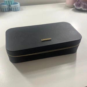 Smyckeskrin Syster P - Smyckeskrin från märket Syster P. Svart med guldiga detaljer. Bra förvaring och organiserar smyckena på ett smidigt sätt. Har endast två små defekter (se de två sista bilderna), annars är det som nytt. Nypris ca 1 200kr. Skriv gärna vid frågor eller funderingar😊