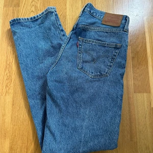 Levi's 501 blå jeans - Klassiska Levi's 501 jeans i blå denim med raka ben och knappgylf. Snygg vintagekänsla med fem fickor och ikonisk läderpatch bak. Storlek W24 L32, använda max 5 gånger!
