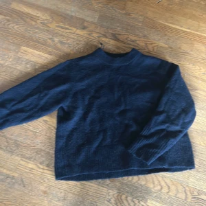 Mörkblå stickad tröja Gina Tricot - Mysig mörkblå stickad tröja från Gina Tricot med rund hals och långa ärmar. Perfekt för kyliga dagar och enkel att matcha med jeans eller kjol. Klassisk modell som funkar till många olika stilar.