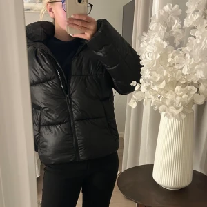 Svart pufferjacka från H&M  - Säljer en svart pufferjacka från H&M i storlek XS. Jackan har en hög krage, dragkedja framtill och en oversized passform. Perfekt för kyliga dagar och enkel att styla till olika outfits. Materialet är otroligt tjockt och den är super varm och så så fin! Den är knappt använd och därav i super bra skick🩷