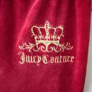 Vintage velourbyxor Juicy Couture - Mysiga velourbyxor från Juicy Couture med broderad krona och logga framtill. Byxorna har resår i midjan med snörning och raka ben. Egentligen storlek L men väldigt små i storlek så ungefär XS/S
