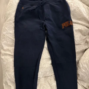 Mörkblå mjukisbyxor Polo Ralph Lauren - Mörkblå mjukisbyxor från Polo Ralph Lauren med broderad logga på benet och liten gul brodyr vid fickan. Perfekta för chill dagar eller när du vill vara bekväm. nypris 1500