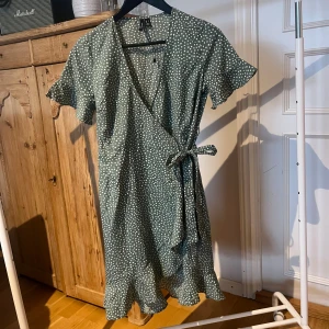 Grön klänning - Säljer en superfin omlott klänning med vita prickar 