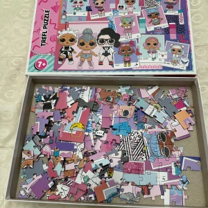 Trefl Puzzle LOL Surprise - Färgglatt pussel med LOL Surprise-motiv, rekommenderat från 7 år. Pusselbitarna är i gott skick och motivet visar flera populära LOL Surprise-karaktärer. Perfekt för barn som gillar pyssel och samlarfigurer.