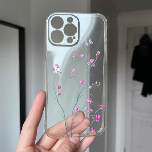 Mobilskal med blommor - Ett transparent mobilskal med rosa blommor som passar till iPhone 13 Pro Max. Sparsamt använt 🩷