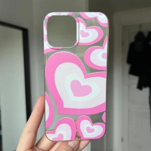 Mobilskal med hjärtmönster - Snyggt mobilskal med ett hjärtmönster i rosa och vitt. Skalet är genomskinligt och designat för att passa till en iPhone 13 Pro Max. Perfekt för att ge din mobil en personlig touch och skydda den samtidigt. 💖