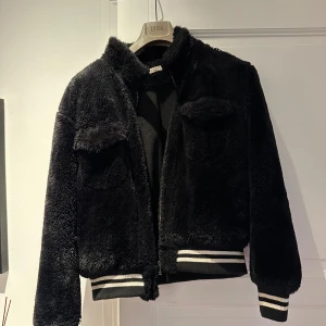 Svart Fur Jacket från Ojardorf - Säljer nu min Svarta Fur Jacket från Ojardorf i storlek XL (sitter som M). Jag är 185cm. Skicket är mycket bra, inga defekter då jag inte använt den mycket då jag snurrar på många jackor.