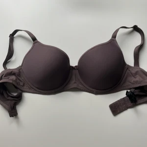 Lila bh från Twilfit 75C - Säljer en lila bh från Twilfit med släta kupor och justerbara axelband. Bh:n har en enkel och stilren design med hakknäppning bak. Tillverkad i mjukt och bekvämt material som känns skönt mot huden.